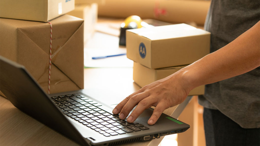 Pessoa fazendo checagem em notebook antes da expedição de mercadorias, uma das etapas das soluções logísticas para e-commerce