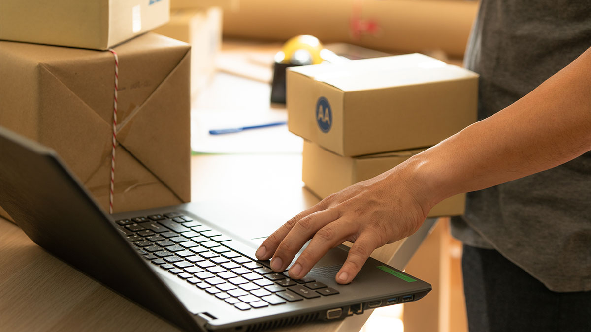 Pessoa fazendo checagem em notebook antes da expedição de mercadorias, uma das etapas das soluções logísticas para e-commerce