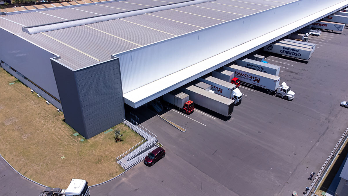 Caminhões da Favorita Transportes e parceiros estacionados em doca de centro logístico, ilustrando preparativos para a Black Friday 2025 na logística.