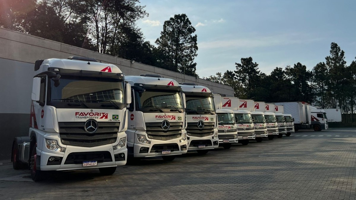 Frota de caminhões da Favorita Transportes alinhados no pátio, representando tecnologia, segurança e eficiência logística.
