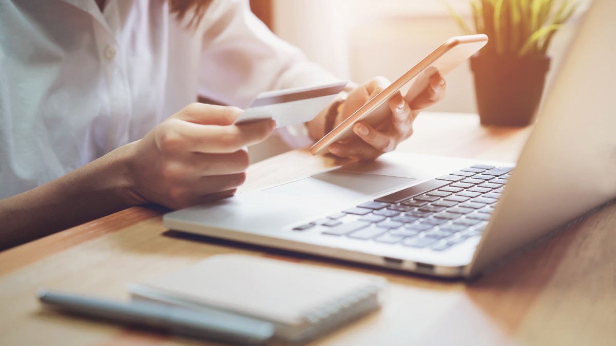Mulher fazendo compra online com cartão de crédito no notebook, representando o crescimento do e-commerce e a importância da logística para Black Friday 2025.