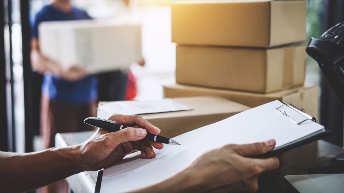 Pessoa com prancheta preenchendo papel e entregador ao fundo segurando encomenda, representando as ações para a Black Friday