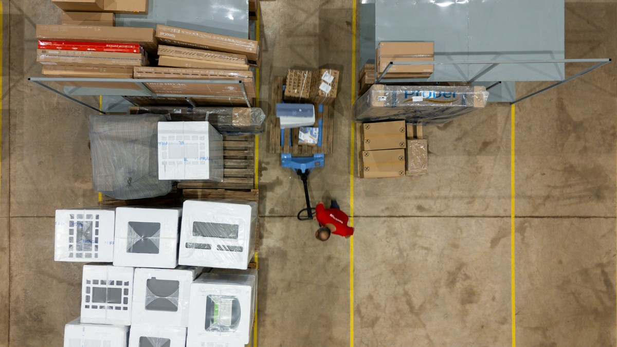 Colaborador da Favorita Transportes manuseia pallets em centro de distribuição durante a Black Friday, demonstrando organização e eficiência, elementos essenciais para uma logística ágil.