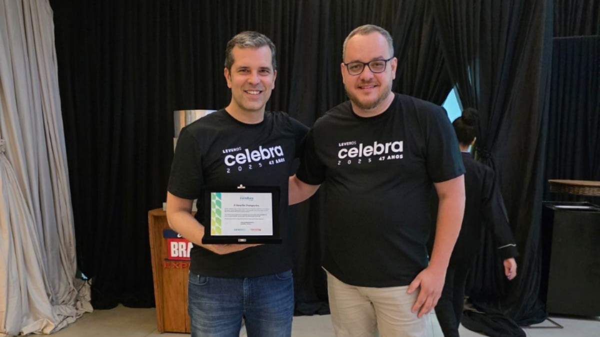 Dois funcionários da Favorita Transportes segurando o Prêmio do Reclame Aqui, representando os prêmios em 2025 recebidos pela empresa